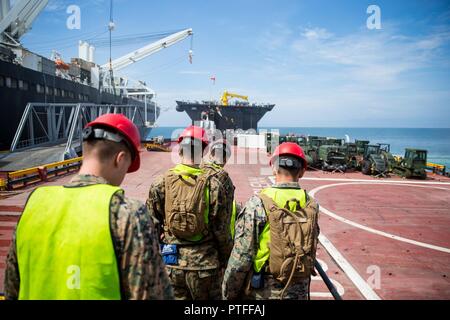 Les Marines américains avec le 1er Groupe Logistique Maritime watch Landing Craft Coussins d'air à bord des terres l'USNS John Glenn lors de l'exercice Pacific Horizon 2017, le 19 juillet 2017. Le rôle de ces marines : rez-de guidage du véhicule et de les nettoyer avant l'entreposage. Horizon 2017 du Pacifique est un prépositionnement maritime Force (MPF) à l'exercice visant à former JE Marine Expeditionary Force (MEF) et les composants de la plage de la Marine du groupe 1 (NBG-1) Marines et marins à l'arrivée et d'assemblage. Banque D'Images