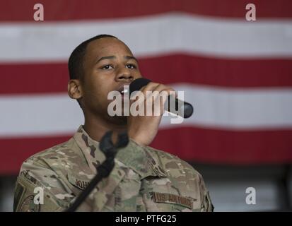 Calvin Johnson, Senior Airman 455 e Escadron des Forces de sécurité, chante l'hymne national au cours de la 455 e Groupe de soutien de mission expéditionnaire cérémonie de passation de commandement à l'aérodrome de Bagram, en Afghanistan, le 20 juillet 2017. Au cours de la cérémonie, le Colonel Bradford Coley a quitté le commandement de la 455 e EMSG au colonel Phillip Noltemeyer. Banque D'Images