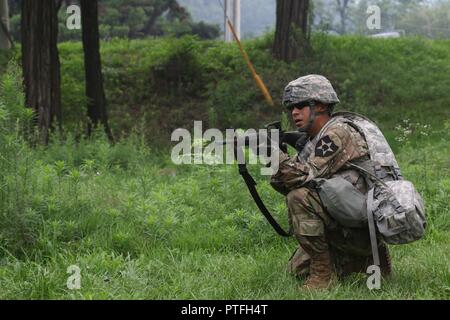 La CPS. Jorge H. Garatecarabajo, un mécanicien de véhicules sur roues, attribué à 579e de l'avant Support Société, 6e Bataillon, 37e Régiment d'artillerie, 210e Brigade d'artillerie, 2e Division d'infanterie/Corée du Sud et les États-Unis, la Division combinés à des incendies des forces ennemies au cours d'une patrouille simulée au Camp Casey, de Corée du Sud, le 21 juillet 2017. La patrouille était partie d'un cours de Life Savers Combat en tant que soldats joué scénario réel de trouver une victime et l'application d'aide médicale. Banque D'Images