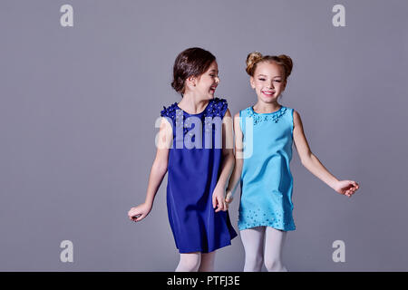 2 deux petites filles s'amuser dans de belles robes élégantes.copines fashion model posing sourire enfants studio pour des vêtements de catalogue. Dame classique pour enfants, ados style. copier l'espace. Banque D'Images