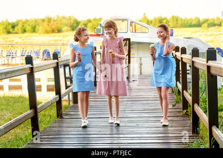 Fashion 3 trois petite amie à 11 ans. Dame élégante robe à rayures, les enfants dans un style marin. Les petites filles cool,des vêtements d'été en plein air.Designer collection pour enfants. Amitié,sourire,se reposer ensemble. Banque D'Images