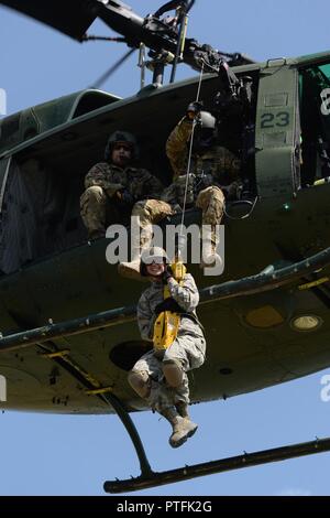 U.S. Air Force d'un membre de la 1re classe Ashlee Wiebe, du 119e Groupe médical, est hissé en haut et en bas de la terre à un 54e Escadron d'Hélicoptères Bell UH-1N d'hélicoptères Iroquois pendant la formation treuil de sauvetage au Camp Gilbert C. Grafton, près de Devils Lake, N.D., le 20 juillet 2017. L'hélicoptère est piloté par le Capitaine Rob Nesko, droite, avec le TEC. Le Sgt. Thomas Liscomb et Trevor Navigant de première classe Beeninga l'exploitation d'un palan. Banque D'Images