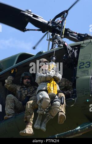 Le sergent de l'US Air Force. Poitra Misty, du 119e Groupe médical, est hissé en haut et en bas de la terre à un 54e Escadron d'Hélicoptères Bell UH-1N d'hélicoptères Iroquois pendant la formation treuil de sauvetage au Camp Gilbert C. Grafton, près de Devils Lake, N.D., le 20 juillet 2017. L'hélicoptère est piloté par le Capitaine Rob Nesko, droite, avec le TEC. Le Sgt. Thomas Liscomb et Trevor Navigant de première classe Beeninga l'exploitation d'un palan. Banque D'Images