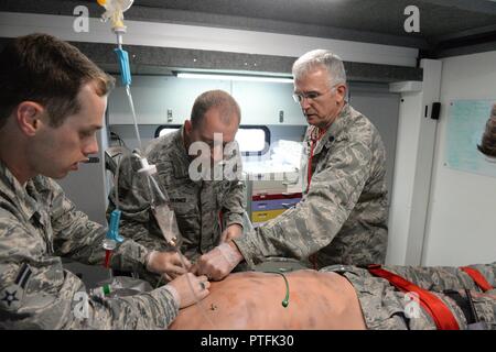 Le Lieutenant-colonel de l'US Air Force Dwight Harley, droite, donne des instructions pour le s.. Daniel Wagner, centre, et d'un membre de la 1re classe Thomas Sorum, tous de la 119e Groupe médical, qu'ils fréquentent à l'état de l'art qui agit comme un mannequin simulateur de patient humain lors d'un scénario de formation médicale au Camp Gilbert C. Grafton, près de Devils Lake, N.D., le 21 juillet 2017. Le Mannequin simulateur humain réaliste et équipements associés fournir des soins pré-hospitaliers et les soins d'urgence de formation pour le personnel médical similaire à ce qu'ils pourraient trouver dans la base d'opérations ou à distance. Banque D'Images