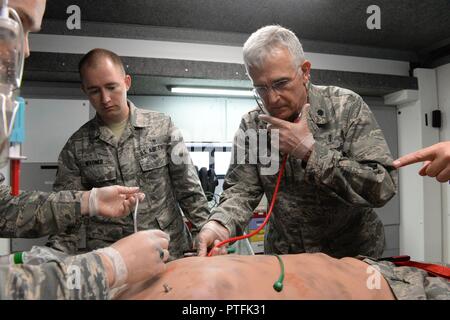 Le Lieutenant-colonel de l'US Air Force Dwight Harley, un fournisseur affecté à la 119e Groupe médical, du Dakota Air National Guard, droite, écoute le battement de cœur de l'état de l'art qui agit comme un mannequin simulateur de patient humain lors d'un scénario de formation médicale comme le s.. Daniel Wagner, centre, et d'un membre de la 1re classe Thomas Sorum, assister au Camp Gilbert C. Grafton, près de Devils Lake, N.D., le 21 juillet 2017. Le Mannequin simulateur humain réaliste et équipements associés fournir des soins pré-hospitaliers et les soins d'urgence de formation pour le personnel médical similaire à ce qu'ils pourraient trouver dans un renv Banque D'Images