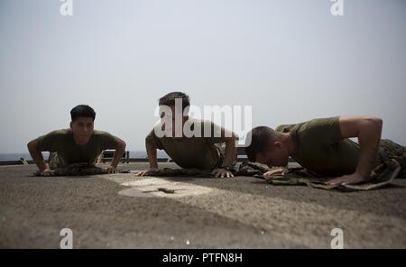 Golfe d'ADEN (21 juillet 2017) U.S. Marine Corps Lance Cpl. Aladdin Rojas, gauche, Joshua Lien, centre, et Quentin Long, droit, tous avec 3e Bataillon, 6ème Marines, travailler sur des exercices de maintien en puissance au cours de Marine Corps cours Programme d'Arts Martiaux à bord de l'USS Carter Hall (LSD 50), le golfe d'Aden, le 21 juillet 2017. La 24e unité expéditionnaire de Marines est actuellement déployée dans la 5e flotte américaine zone d'opérations à l'appui d'opérations de sécurité maritime visant à rassurer les alliés et les partenaires et de préserver la liberté de navigation et la libre circulation du commerce dans la région. Banque D'Images