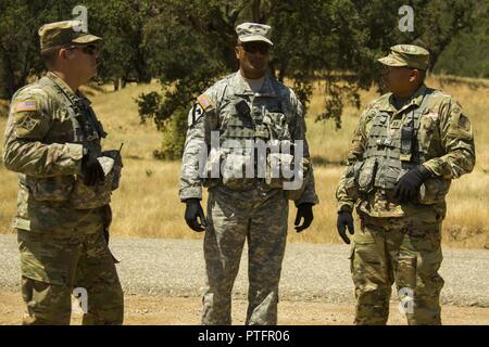 Le colonel Flint Patterson, commandant de la 4e Brigade de cavalerie Formation multifonctionnel, centre, se réunit avec le s.. Nathnam à l'Ouest, à gauche, et le capitaine Gustavo Madrigal, droite, à la fois entraîneur observateur/formateurs avec 4e CAV MFTB, pour discuter des progrès accomplis par la 718e compagnie du génie de combat à l'horizontale Support Formation Exercice 91-17-03 12 Juillet 2017 à Fort Hunter Liggett, CA. CSTX est un exercice dirigé par la Division de la Formation 91e conçu pour aider à combattre et lutter contre le service service-unités d'appui à la planification, la préparation, la supervision et l'exécution de la formation collective de mobilisation. Banque D'Images