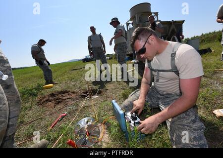 Oregon Air National Guard, 270e Escadron de contrôle de la circulation aérienne, l'airman Timothy Schneider vérifie l'ohm la résistance d'un fil de masse relié à l'élément de contrôle aérien tactique et l'unité de navigation (arrière-plan) à l'agression de l'air d'une bande au Fort McCoy, Wisconsin (Etats-Unis), le 19 juillet 2017. Le contrôle aérien tactique et un équipement de navigation (TACN) est un appareil de navigation radio sida pilotes pendant le décollage et l'atterrissage. Banque D'Images