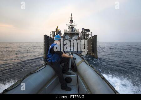 Le Golfe Arabique (18 juillet 2017) 2e classe Mécanicien Élie Stamets se prépare à recevoir un fixant la conduite comme un canot pneumatique à coque rigide (RHIB) renvoie à la patrouille côtière USS Squall (PC 7) au cours d'un test de compétence et de l'évolution de l'incendie du système de missiles de croisières 5 griffin du PC dans le Golfe Arabe, le 18 juillet. Squall est l'un des dix navires de patrouille côtière affectés à l'Escadron de patrouille côtière (PCRON) 1 home-porté à Manama, Bahreïn à l'appui d'opérations de sécurité maritime et les efforts de coopération en matière de sécurité dans le théâtre dans la 5e flotte américaine zone d'exploitation. Banque D'Images