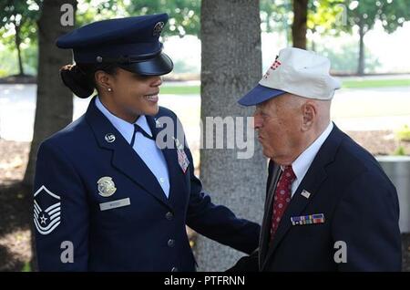 Le sergent-chef. Tamekia Bois, US Air Force, de la garde d'honneur aide slt (Ret.) Jean Pedevillano avant son Purple Heart cérémonie le 14 juillet 2017 à l'US Air Force Memorial, Arlington, Va., le général James A. Jacobson, Air Force, commandant du district de Washington a accueilli la Purple Heart cérémonie et a présenté le prix prestigieux de slt (Ret.) Jean Pedevillano pour blessures subies au cours d'une marche forcée à la Seconde Guerre mondiale, prisonnier de guerre en Allemagne. Pedevillano, un bombardier B-17, pilote et son équipage affecté à la 306e Groupe de bombardement de la "Mighty Eighth Air Force" ont été abattus dow Banque D'Images