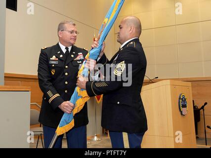 Le colonel de l'Armée de Mark Simerly, DLA Troop soutiennent l'Commandant, passe le drapeau de l'Armée de DLA Master Sgt. Jose Moraga, DLA Troop l'appui des états de service s'engage, lors de la cérémonie de passation de commandement le 11 juillet à Philadelphie. Simerly était auparavant le directeur de capacités, le développement et l'intégration avec le soutien au commandement interarmes, Fort Lee Virginia. Banque D'Images