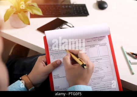 L'homme est la forme de remplissage avec stylo. Photo de feuille OMR sur le presse-papiers. Banque D'Images