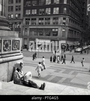 Années 1960, historiques, femme au foulard lire un journal posé sur les marches à l'entrée de la bibliothèque publique de New York (bâtiment principal) à Midtown Manhattan, New York City, New York, USA. Banque D'Images