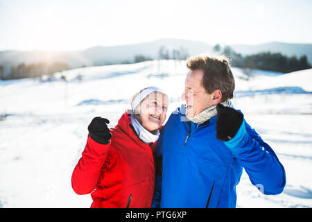 Senior couple porteur debout dans la nature, le repos d'hiver. Banque D'Images