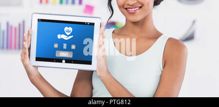 Composite image of businesswoman showing digital tablet in creative office Banque D'Images