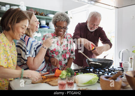 Senior friends cooking in kitchen Banque D'Images