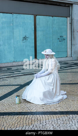 La femme en blanc, interprète de rue dans une rue à Lisbonne, Portugal Banque D'Images