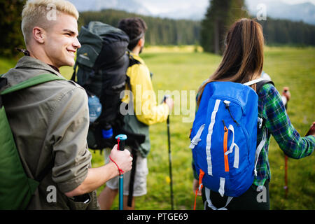 Groupe d'amis sont la randonnée en montagne. Les jeunes gens marchant à travers la campagne. Banque D'Images