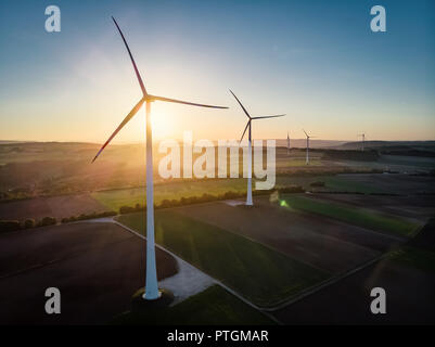 Groupe d'éoliennes autour de drone aérien en vue coucher du soleil doré. Banque D'Images