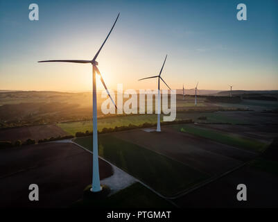 Groupe d'éoliennes autour de drone aérien en vue coucher du soleil doré. Banque D'Images