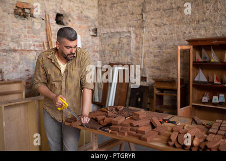 Menuisier qualifié coupe un morceau de bois Banque D'Images