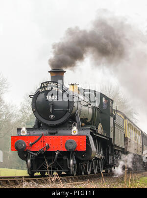 Gros plan sur le train à vapeur britannique en mouvement, peu incliné, pour éliminer la fumée noire. Locomotive à vapeur ancienne, vue avant, s'approchant sur la voie ferrée. Banque D'Images