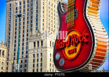 En forme de guitare légendaire de billboard Hard Rock Cafe à Varsovie, en Pologne, avec le Palais de la culture derrière. Banque D'Images