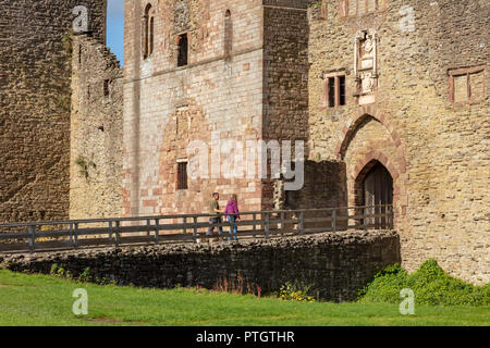 Un couple traverser les douves de Ludlow Castle, Ludlow, Shropshire, Angleterre Banque D'Images