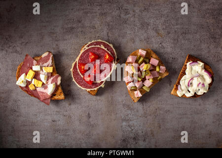 Jeu de sandwichs ouverts avec des œufs durs, des concombres, de salami, de fromage et de viande fumée - Vue de dessus Banque D'Images