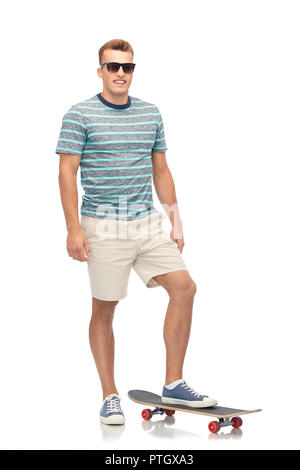 Smiling Young man with skateboard over white Banque D'Images