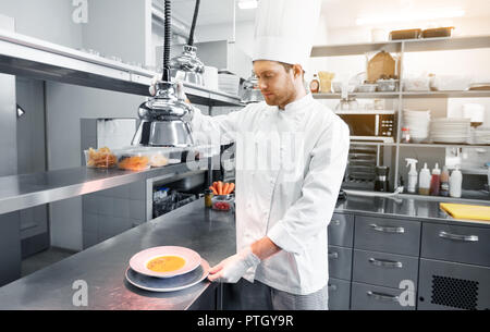 Heureux homme, la cuisson à chef de cuisine restaurant Banque D'Images