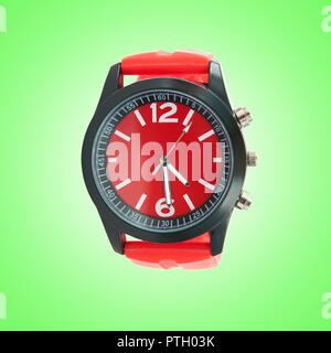 Horloge rouge sur fond vert. Banque D'Images