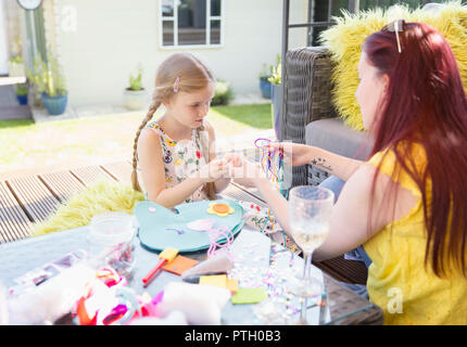 Mère et fille faire craft project on patio Banque D'Images