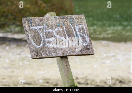 Signe extérieur de graffitis : "Jésus vous aime", un message religeous de promouvoir la foi chrétienne, au Royaume-Uni. Banque D'Images