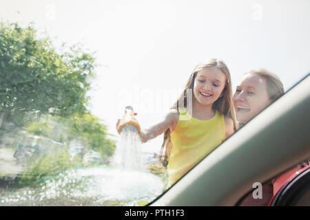 Mère et fille lave le pare-brise de voiture Banque D'Images