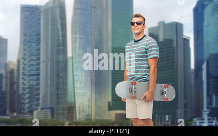 Jeune homme avec skateboard sur Singapour ville Banque D'Images