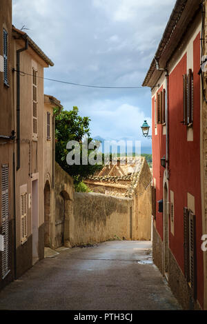 La lumière du soleil illumine un bâtiment abandonné après la pluie dans un village de Majorque. Banque D'Images