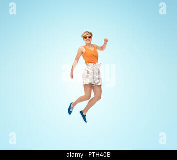 Teenage girl jumping in snow Banque D'Images