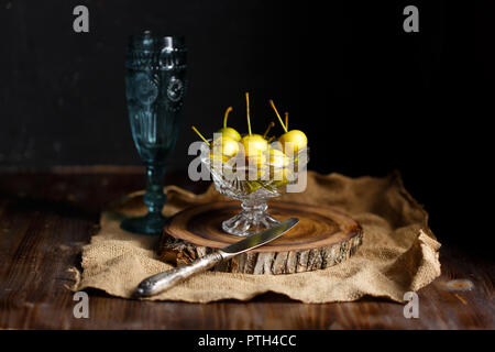 Poirier dans un bol en verre et un verre de vin maison en bois sur un fond sombre. Concept rustique Copy space Banque D'Images