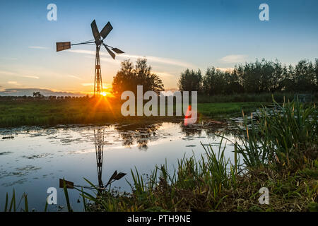 Dutch Windmill Silhouette contre le soleil couchant Banque D'Images