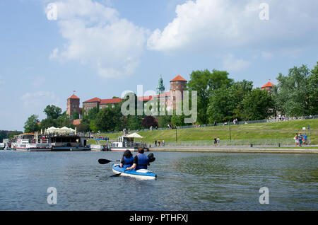 Château de Wawel à Cracovie. Vue depuis le côté de la Vistule. Au premier plan les canoéistes flottant sur la Vistule. Banque D'Images