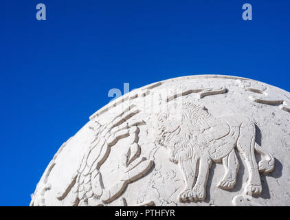 Leo le Lion et le cancer le crabe sur un globe de pierre contre un fond de ciel bleu. Banque D'Images