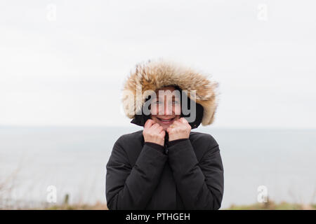 Portrait of smiling woman in manteau à capuchon de fourrure Banque D'Images