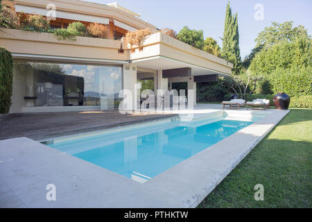 Piscine privée en face un appartement avec bancs et chaises longues Banque D'Images