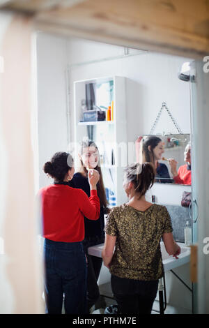 Les jeunes femmes les amis se préparer, appliquant le maquillage dans la salle de bains Banque D'Images