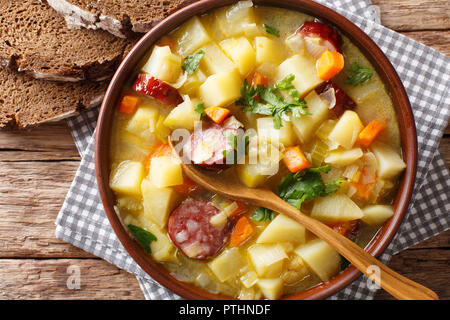 Cocotte soupe de pommes de terre allemande (kartoffelsuppe) Gros plan sur une assiette sur la table. Haut horizontale Vue de dessus Banque D'Images