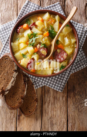 Épaisseur de légumes soupe de pommes de terre avec les saucisses dans un bol sur la table. Haut Vertical Vue de dessus Banque D'Images