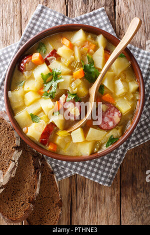 Cocotte soupe de pommes de terre allemande (kartoffelsuppe) Gros plan sur une assiette sur la table. Haut Vertical Vue de dessus Banque D'Images