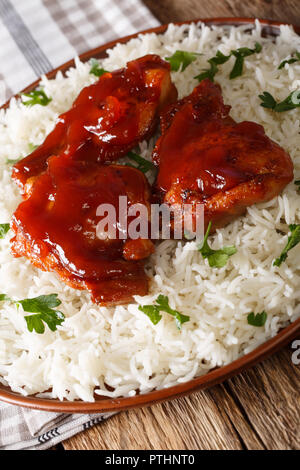 Des cuisses de poulet avec sauce Catalina servi avec du riz sur une plaque verticale. Banque D'Images