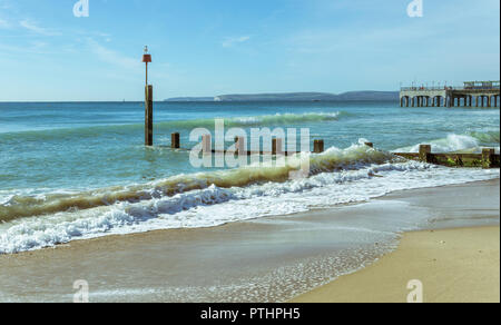 Les vagues déferler sur les épis à Boscombe Bournemouth, Royaume-Uni. La jetée en arrière-plan. Prise le 7 octobre 2018. Banque D'Images